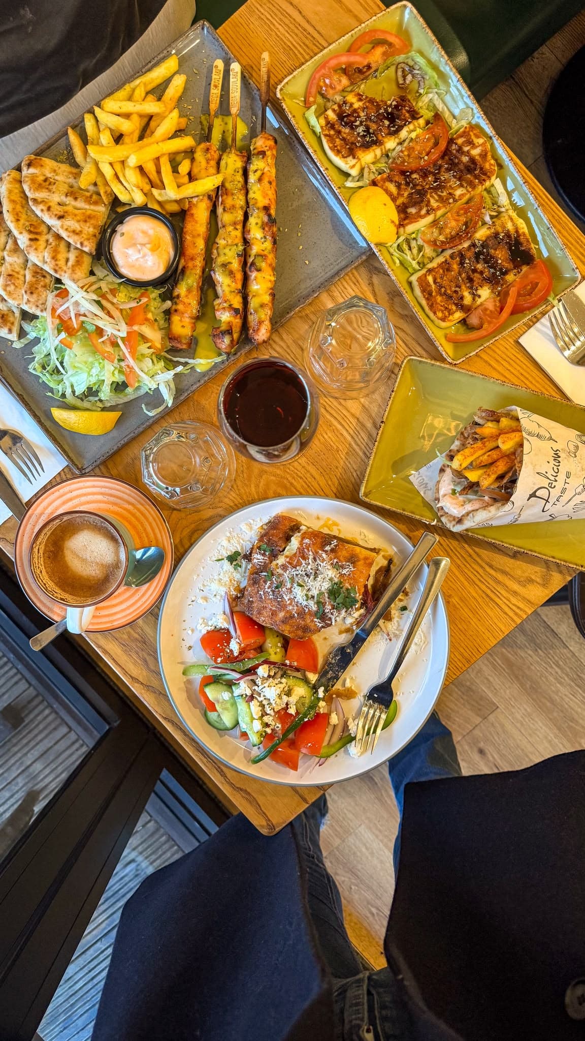 A spread of Greek Unique dishes: mixed grill, halloumi, gyros wrap and moussaka